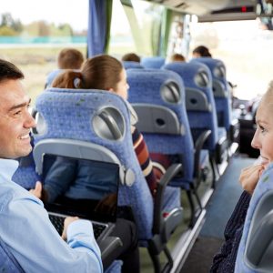 transport, tourism, road trip and people concept - group of happy passengers or tourists in travel bus