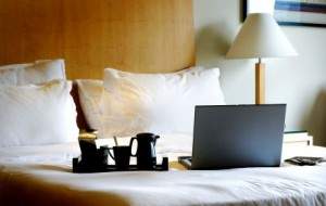 laptop on hotel bed.s600x600 300x190 1 1